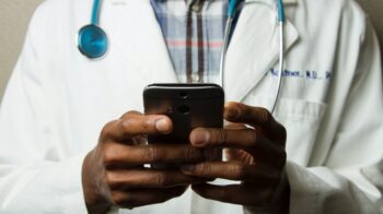 Doctor using iPhone during Telehealth visit